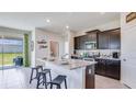 Eat-in kitchen with dark cabinets, granite counters, stainless appliances, and a breakfast bar at 4050 Nw 48Th Terrace Rd, Ocala, FL 34482