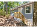 Exterior of the home featuring wood siding, white trim and a new wooden staircase leading up to the front door at 6840 Sw 198Th Ave, Dunnellon, FL 34431