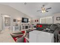 Comfortable living room features neutral walls, a plush sectional sofa, ceiling fan, and adjacent bath at 7886 Sw 103Rd Loop, Ocala, FL 34476