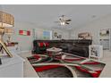 Cozy living room features neutral walls, plush sectional, ceiling fan, and eye-catching decorative rug at 7886 Sw 103Rd Loop, Ocala, FL 34476