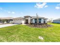 Beautiful single-story home with a well-maintained lawn, three-car garage, and inviting curb appeal at 8497 Sw 99Th Cir, Ocala, FL 34481