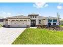 Lovely single-story home featuring a three-car garage, vibrant lawn, and charming architectural details at 8497 Sw 99Th Cir, Ocala, FL 34481