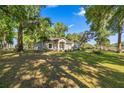 Single-story home featuring a large lawn and mature trees providing ample shade at 8630 Sw 20Th Ct, Ocala, FL 34476