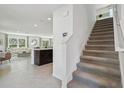 Inviting living space featuring a staircase, light tile flooring, and an open layout with modern accents at 8632 Sw 44Th Ter, Ocala, FL 34476