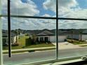 Neighborhood view showing well-maintained lawns and similar home styles, seen through a window at 9326 Sw 57Th Ter, Ocala, FL 34476