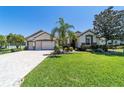 Spacious home exterior with a large, well-kept lawn, mature landscaping, and a three-car garage at 9443 Sw 71St Loop, Ocala, FL 34481