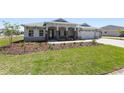 Inviting single-story residence featuring a spacious three-car garage and well-maintained landscaping at 9973 Sw 107Th Ter, Ocala, FL 34481