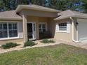 Inviting front entrance with a brick walkway, manicured bushes, and a cozy bench at 11653 Sw 72Nd Cir, Ocala, FL 34476