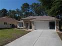 Well-maintained single-story home with neutral colors, a spacious driveway, and attached two-car garage at 11653 Sw 72Nd Cir, Ocala, FL 34476