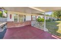 Covered porch with decorative brick accents and a railing, offering a cozy outdoor space at 12351 Se Hwy 464, Ocklawaha, FL 32179