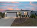 Charming single-story home featuring a well-manicured front yard, a two-car garage, at twilight at 13423 Sw 48Th Ave, Ocala, FL 34473