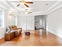 Bright living room with light walls, hardwood floors, and a comfortable brown leather couch at 16295 W Highway 40, Ocala, FL 34481