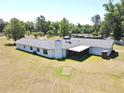 Back of home showing a screened in porch, chimney, and fenced acreage at 1711 Sw 63Rd St Rd, Ocala, FL 34476