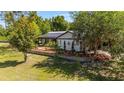 Inviting home with a metal roof, enhanced by well-maintained landscaping and mature trees, creating a peaceful ambiance at 18695 Ne 5Th Terrace Rd, Citra, FL 32113