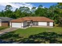 Charming one-story home with a well-maintained lawn and attached two-car garage at 2312 Sw 140Th Ct, Ocala, FL 34481