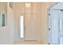 Inviting foyer with a decorative light fixture, tiled floor and a bright white front door with sidelight at 2339 Nw 55Th Avenue Rd, Ocala, FL 34482