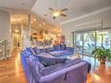 Open-concept living room with hardwood floors, blue sofa, and sliding glass doors to the backyard and outdoor spaces at 2410 Se 23Rd Pl, Ocala, FL 34471