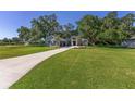 Well-manicured front yard showcasing beautiful landscaping, a long driveway, and a charming exterior with stone accents at 2515 Se 77Th St, Ocala, FL 34480