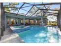Screened pool with integrated spa features a tile surround and ample space for entertaining with views of the backyard at 2515 Se 77Th St, Ocala, FL 34480