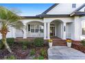 Inviting front porch with brick flooring, white railings, rocking chairs, and a warm welcome wreath on the front door at 4083 Se 38Th Loop, Ocala, FL 34480