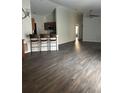 Open living space with wood floors, vaulted ceiling, ceiling fan and breakfast bar with seating at 627 Vagabond St, The Villages, FL 32163