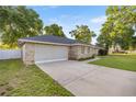 Side view of a beautiful single-story home with a spacious two-car garage and driveway at 8215 Sw 53Rd Ct, Ocala, FL 34476