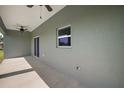 Back patio featuring two fans, a window, and sliding glass doors at 8725 Sw 136Th Ter, Dunnellon, FL 34432