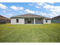 Large backyard featuring a lush green lawn and the back of the house, with sliding glass doors at 8725 Sw 136Th Ter, Dunnellon, FL 34432