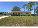 Charming single-story home featuring a covered carport and a well-maintained front yard at 10040 Sw 93Rd Ct, Ocala, FL 34481