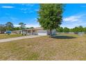 View of the side of the home, featuring an attached garage, screened-in porch, and spacious yard at 10946 Sw 65Th Ave, Ocala, FL 34476