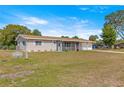 Inviting single-story home with a screened-in porch, attached garage, and lush green lawn at 10946 Sw 65Th Ave, Ocala, FL 34476