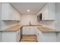 A compact modern kitchen is showcasing bright white cabinets, a granite countertop, subway backsplash and stainless steel appliances at 1325 42Nd St, Orlando, FL 32839