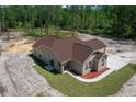 Aerial view of a cozy single-story home with a covered carport and lush landscaping in a private, wooded area at 13491 E Hwy 316, Fort Mc Coy, FL 32134