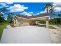 A view of a single-story home featuring a spacious covered carport and a beautifully landscaped front yard at 13491 E Hwy 316, Fort Mc Coy, FL 32134