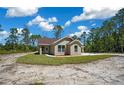 Charming single-story home with a covered carport, surrounded by greenery and a natural wooded setting at 13491 E Hwy 316, Fort Mc Coy, FL 32134