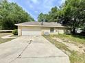 Side view of home showing garage, driveway, and part of the yard at 26 Hemlock Circle Way, Ocala, FL 34472