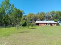 View of the single-story home with an entrance porch, a metal roof and several windows set amongst lush greenery at 2630 Nw 140Th St, Citra, FL 32113