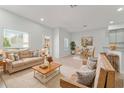 Bright living room featuring neutral decor, comfortable seating, and ample natural light throughout the living space at 288 N Oak Ave, Sanford, FL 32771