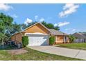Side view of a well maintained single-story home with an attached two car garage and ample yard space at 2940 N Huron Dr, Deltona, FL 32738