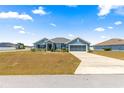 Beautiful single-story home with blue exterior, an attached two-car garage, and a well-maintained lawn at 4881 Se 91St Pl, Ocala, FL 34480