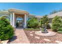 Beautiful home with a decorative water fountain and a brick walkway leading to the columned front entrance at 5090 Nw 80Th Avenue Rd, Ocala, FL 34482