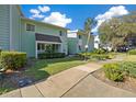 Inviting condominium with lush landscaping along the sidewalk, and clear blue skies at 515 Midway Dr # A, Ocala, FL 34472