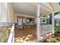 Inviting covered front porch with stone accents, white railings, and tile flooring at 8831 Sw 94Th Ln # H, Ocala, FL 34481