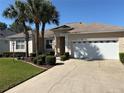 Lovely home features a two-car garage, a well-manicured lawn, and fresh landscaping at 9288 Sw 93Rd Cir, Ocala, FL 34481