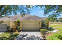 Attached two-car garage and mature landscaping with view of the golf course at 9591 Sw 70Th Loop, Ocala, FL 34481