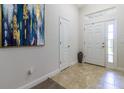 Inviting foyer with neutral tile flooring, transom window, and elegant artwork at 9721 Sw 53Rd Ct, Ocala, FL 34476