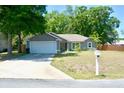 Inviting single-story home boasts an attached garage, mature trees, and a pristine lawn at 10 Banyan Track Way, Ocala, FL 34472
