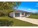 Single-story home with an attached garage, showcasing a well-maintained lawn and inviting curb appeal at 10605 Se 146Th Ln, Summerfield, FL 34491