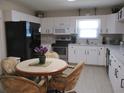 Well-lit kitchen featuring white cabinets, modern appliances, and a cozy dining area at 13675 Sw 111Th Ave, Dunnellon, FL 34432