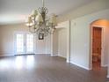 Spacious living room with wood floors, chandelier, and access to a bathroom and french doors at 13675 Sw 111Th Ave, Dunnellon, FL 34432